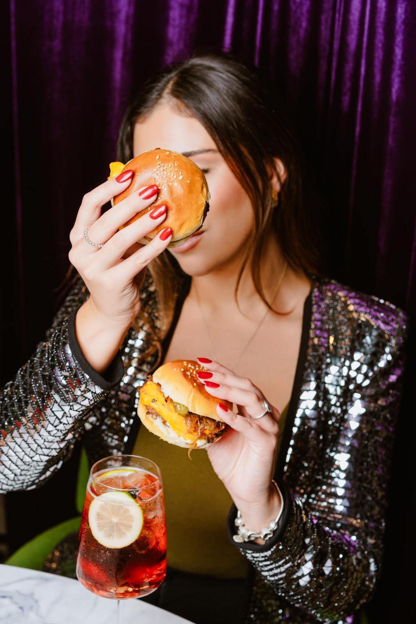 Hotel Pullman Santiago El Bosque Zewnętrze zdjęcie A woman eating a hamburger